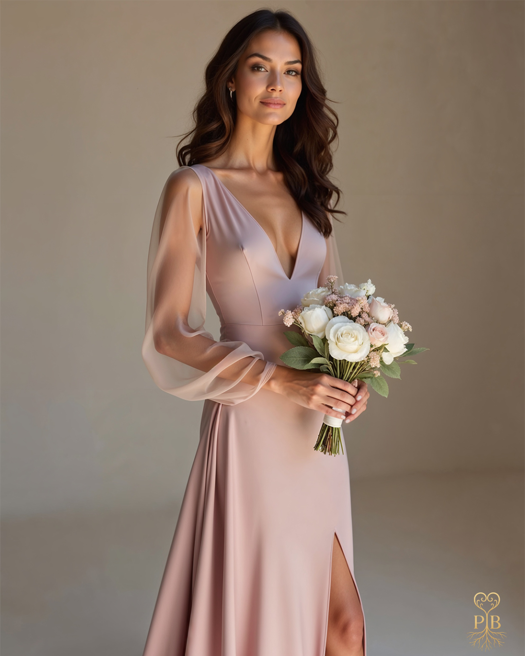 “Bride wearing a warm rosé gown with sheer sleeves and a thigh-high slit, holding a bouquet of white and blush flowers in a softly lit neutral space.”